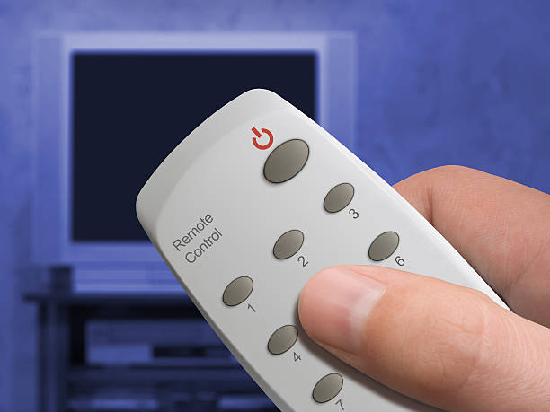 control remoto en las manos y televisor - remote control close up selector gray fotografías e imágenes de stock
