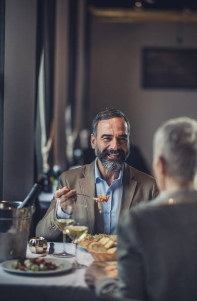 istock Happy mature couple communicating while having lunch in a restaurant. 909440252