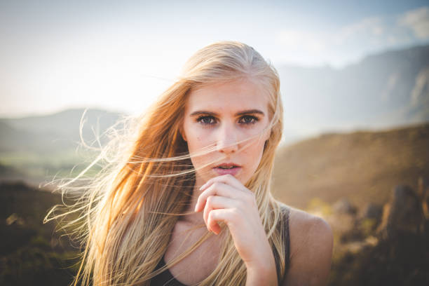 Portrait of a beautiful blond female model in a natural setting with stunning back light