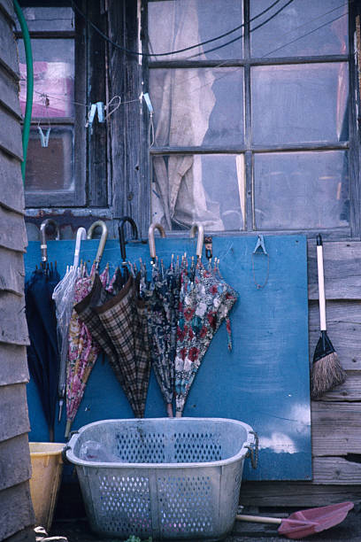 On a sunny day, three light blue umbrellas are lined up to dry. The rain boots are also the same light blue, creating a pop and cute image of an ordinary everyday scene.