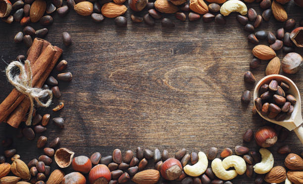 istock Different nuts on a wooden table. Cedar, cashew, hazelnut, walnu 909445840