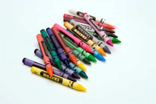 Multi Coloured Crayons set against a plain backgrund.