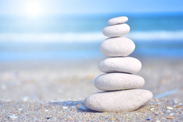 zen-like stones on beach under sun - balance simplicity nature beach imagens e fotografias de stock