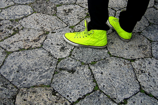 Person wearing bright yellow high top shoes.