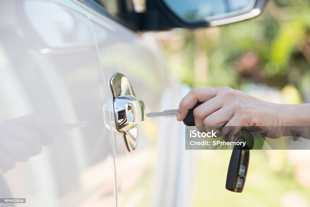 woman hand holding the remote control to unlock the car door Car Stock Photo