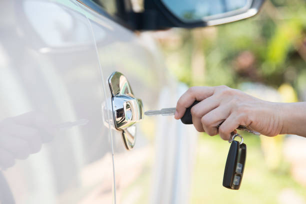 woman hand holding the remote control to unlock the car door - car car door car key door imagens e fotografias de stock