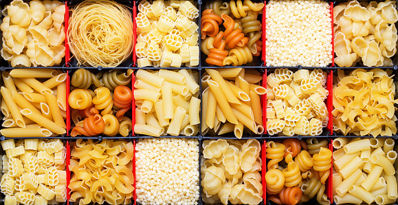 Variety of types, colors and shapes of Italian pasta. Dry pasta background