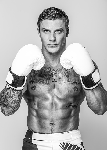 A studio shot of a boxer wearing white gloves