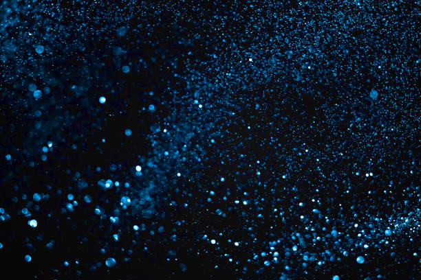 istock christmas blue gradient sparkle glitter explosion dust particles background with bokeh, color holiday happy new year and valentine day love, relationship 909453482