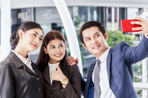 istock Business people taking selfie on smartphone outside office 909453788
