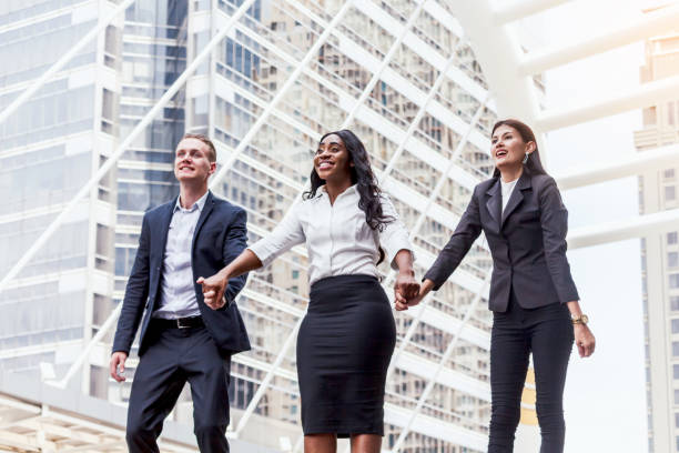 istock Group of businessmen in a row holding hands 909453868