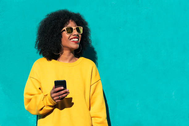 아름 다운 아프리카 미국 여자 길거리에서 모바일을 사용 하 여. - technology mobile phone clothing smiling 뉴스 사진 이미지