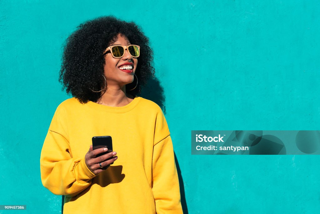 Beautiful afro american woman using mobile in the street. Beautiful afro american woman using mobile in the street. Communication concept. Women Stock Photo