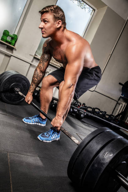 istock Muscular man doing sports with bar 909457466