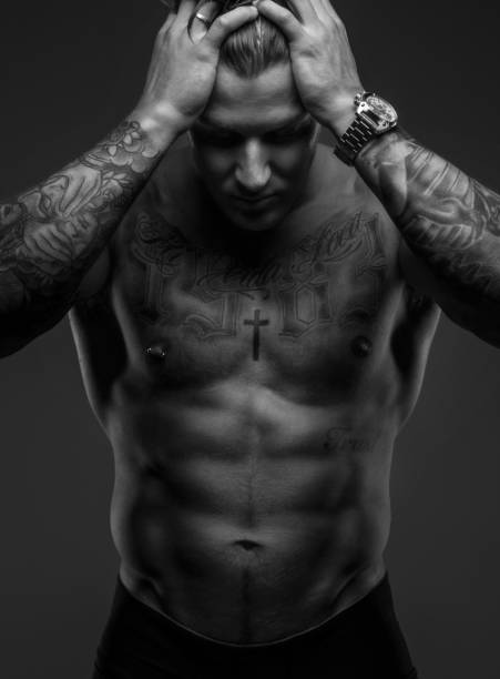 istock Tattooed muscular guy holding his head 909458040