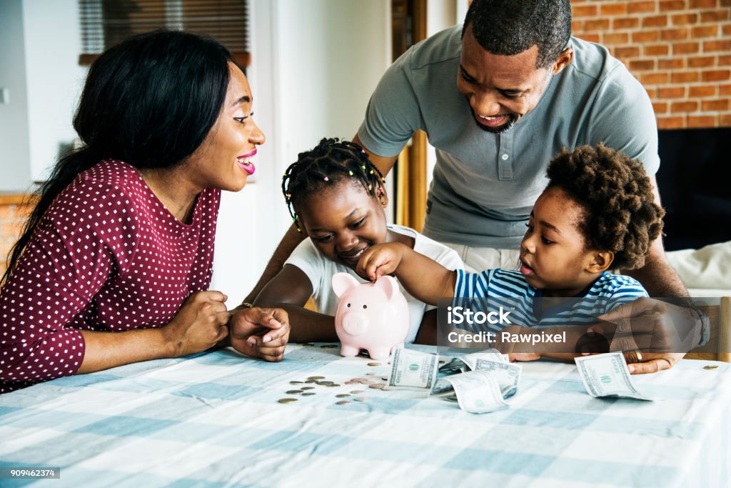 Family saving money to piggy bank Family Stock Photo