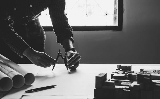 istock Concept architects,engineer holding Circus pointing equipment architects On the desk with a blueprint in the office, Vintage, Sunset light.Selective Focus 909463248