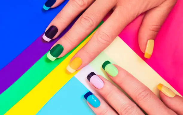 Multicolored pastel manicure in combination of tone in tone with a striped background.