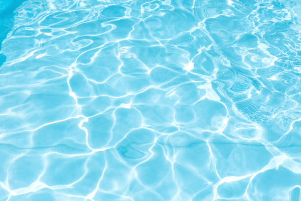 istock Blue and bright water surface with sunreflection in swimming pool 909469166