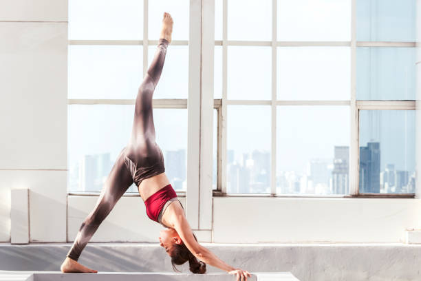 istock Woman practicing yoga on city view 909469222
