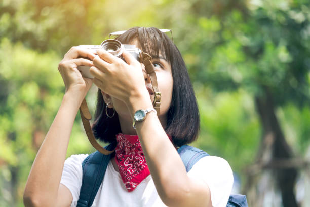 istock Asian woman taking picture with camera 909469384
