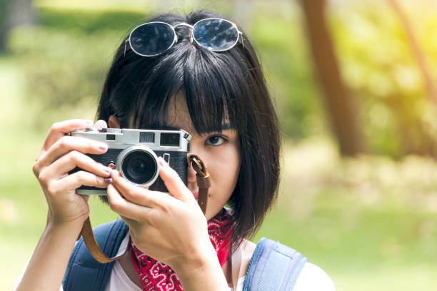 istock Asian woman taking picture with camera 909469390