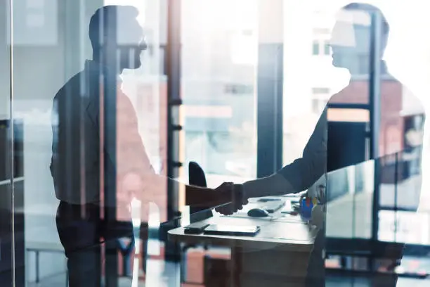 Shot of two businessmen shaking hands in an office