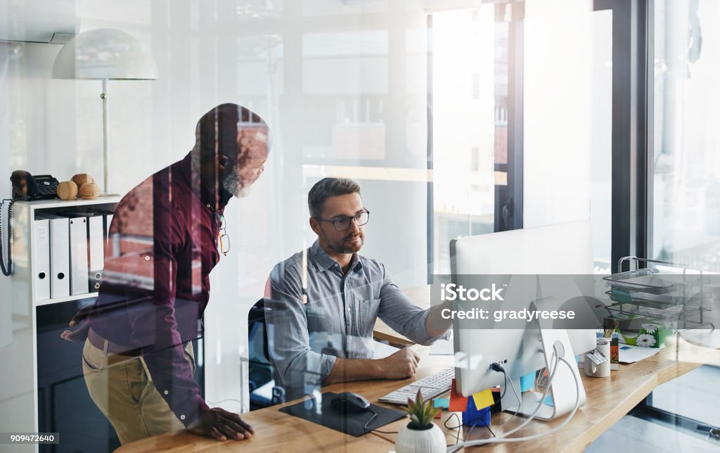 Always be open to critique Shot of two businesspeople working on a computer in an office Teamwork Stock Photo