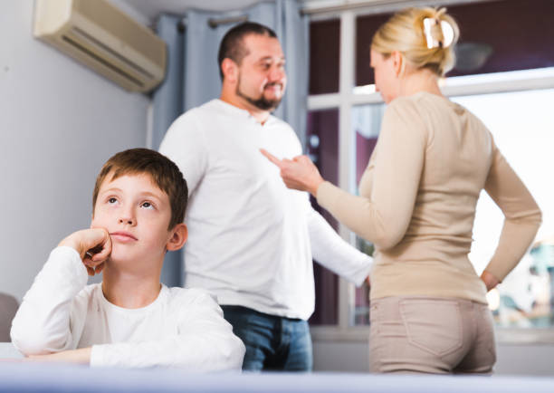 istock unhappy boy at home while parents quarreling 909473344