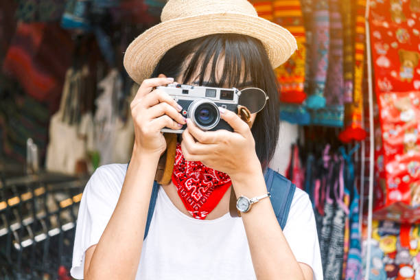 istock Asian woman taking picture with camera 909474088