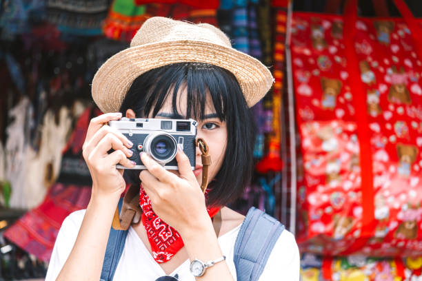 istock Asian woman taking picture with camera 909474096