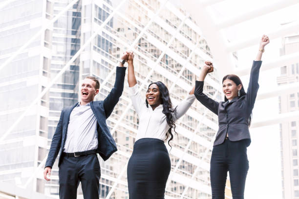 istock Group of businessmen in a row holding hands 909475498