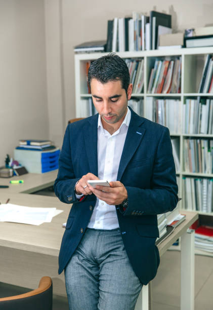 istock Businessman looking his smartphone in the office 909481124