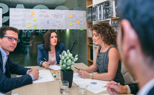 Businesswoman talking in a meeting to teamwork Businesswoman talking in a business meeting to teamwork sitting at table in company headquarters chief of staff stock pictures, royalty-free photos & images