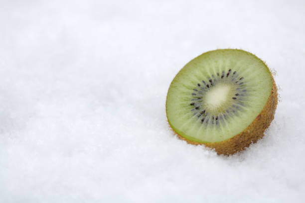 green kiwi fruit on cold winter snow background