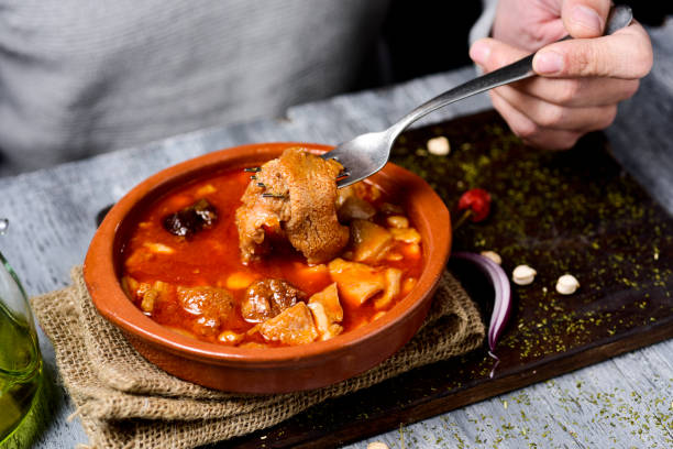 istock man eating spanish callos, a stew with beef tripe 909485560