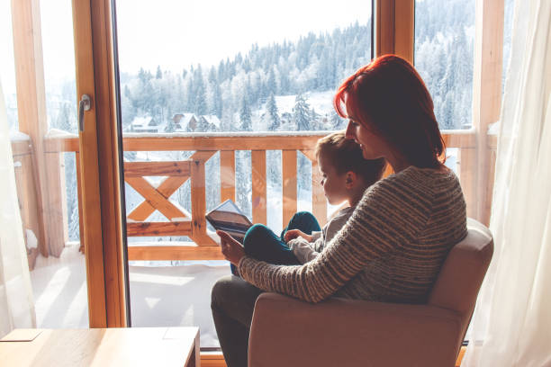 istock Mother and her son sitting in a comfortable chair with tablet 909488508