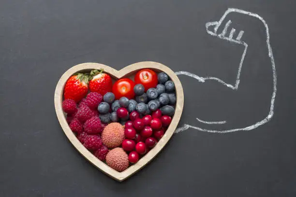 Photo of Health diet heart abstract concept with strongman hand on blackboard