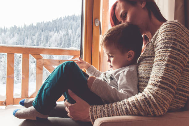 istock Mother and her son sitting in a comfortable chair with tablet 909493218
