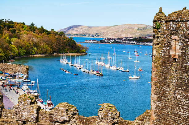 Fisherman boat harbour village Fisherman boat harbour village in Wales, UK, england cloudy sky and green hillsFisherman boat harbour village in Wales, UK, england cloudy sky and green hillsFisherman boat harbour village in Wales, UK, england cloudy sky and green hills maltese silhouette stock pictures, royalty-free photos & images