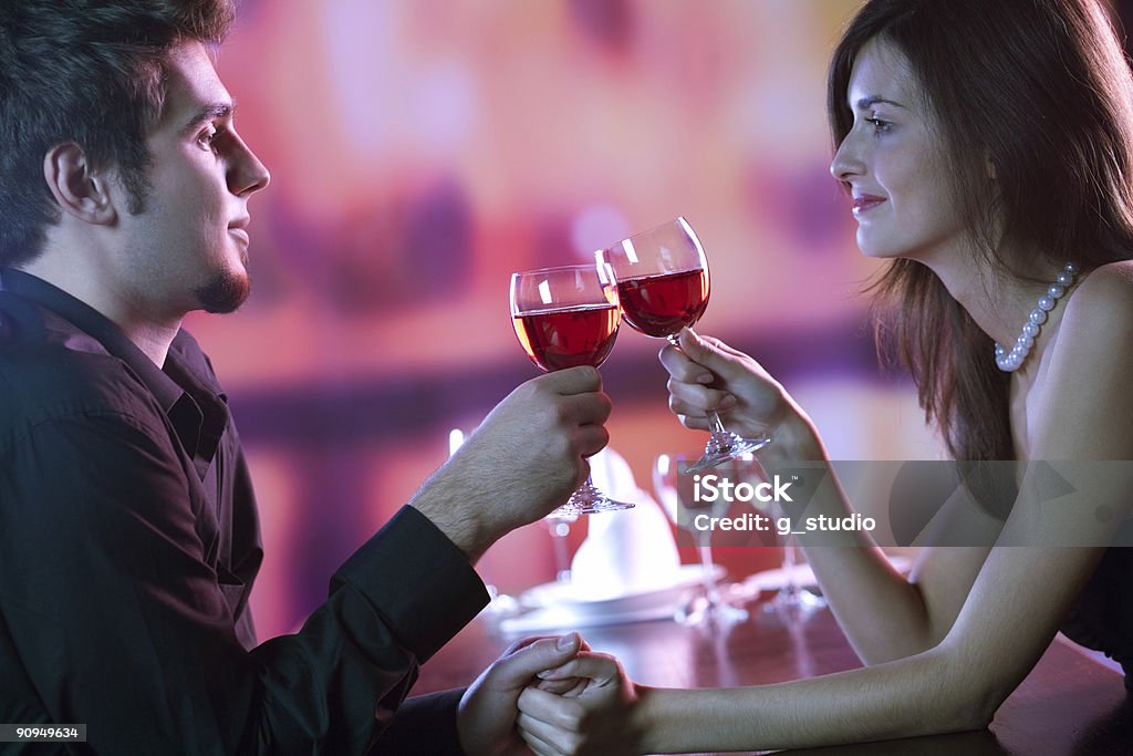 Casal compartilhar um copo de vinho tinto no restaurante, celebrando - Foto de stock de Abraçar royalty-free