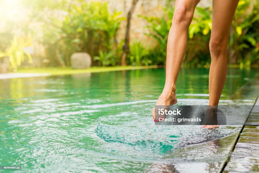 Woman splashing pool water with her leg Close-up -photo of woman splashing pool water with her leg Leg Stock Photo