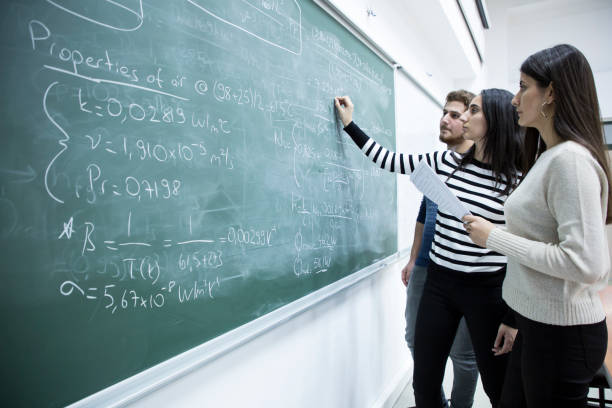 Studying mathematical formula in the classroom Young and beautiful students studying mathematical formula in front of the blackboard mathematical function stock pictures, royalty-free photos & images