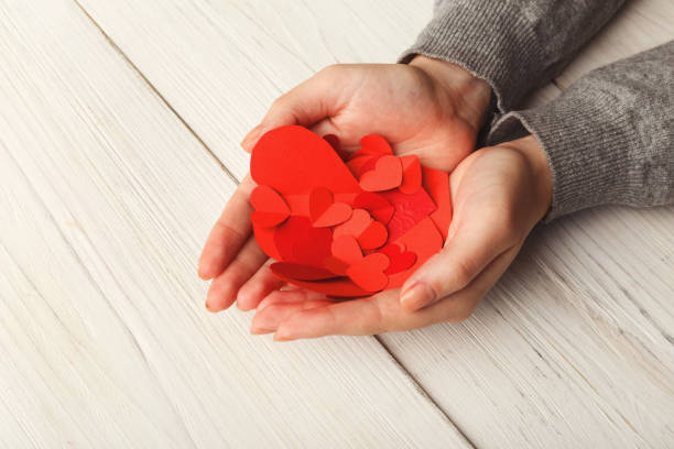 istock Valentine day background, hearts in female hands 909499980
