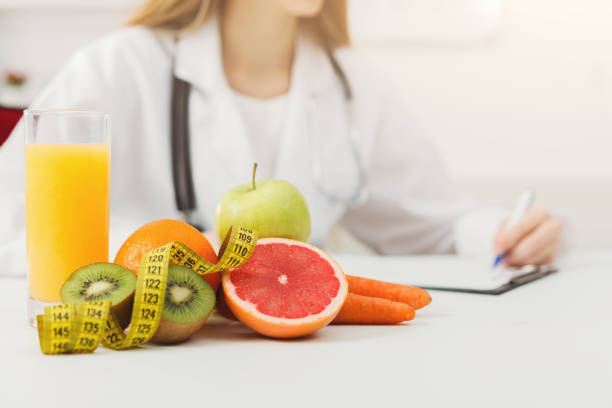 istock Nutritionist desk with fruit and measuring tape 909508894