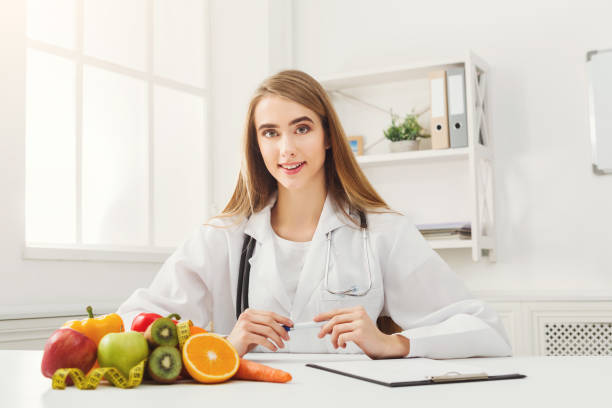 istock Nutritionist desk with fruit and measuring tape 909508924