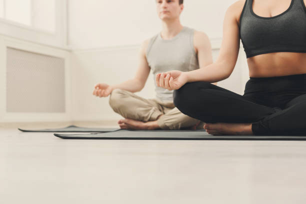 istock Young couple meditating together in studio 909509110
