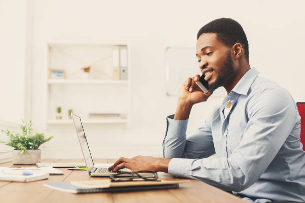 istock Young black businessman talking on mobile phone 909509244