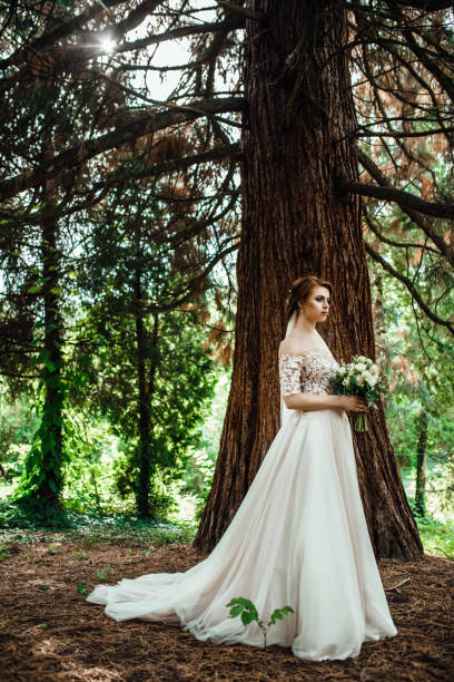istock Bride with stunning pastel bouquet in her hands poses outside 909510404