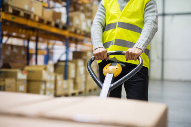 istock Male warehouse worker pulling a pallet truck. 909513058
